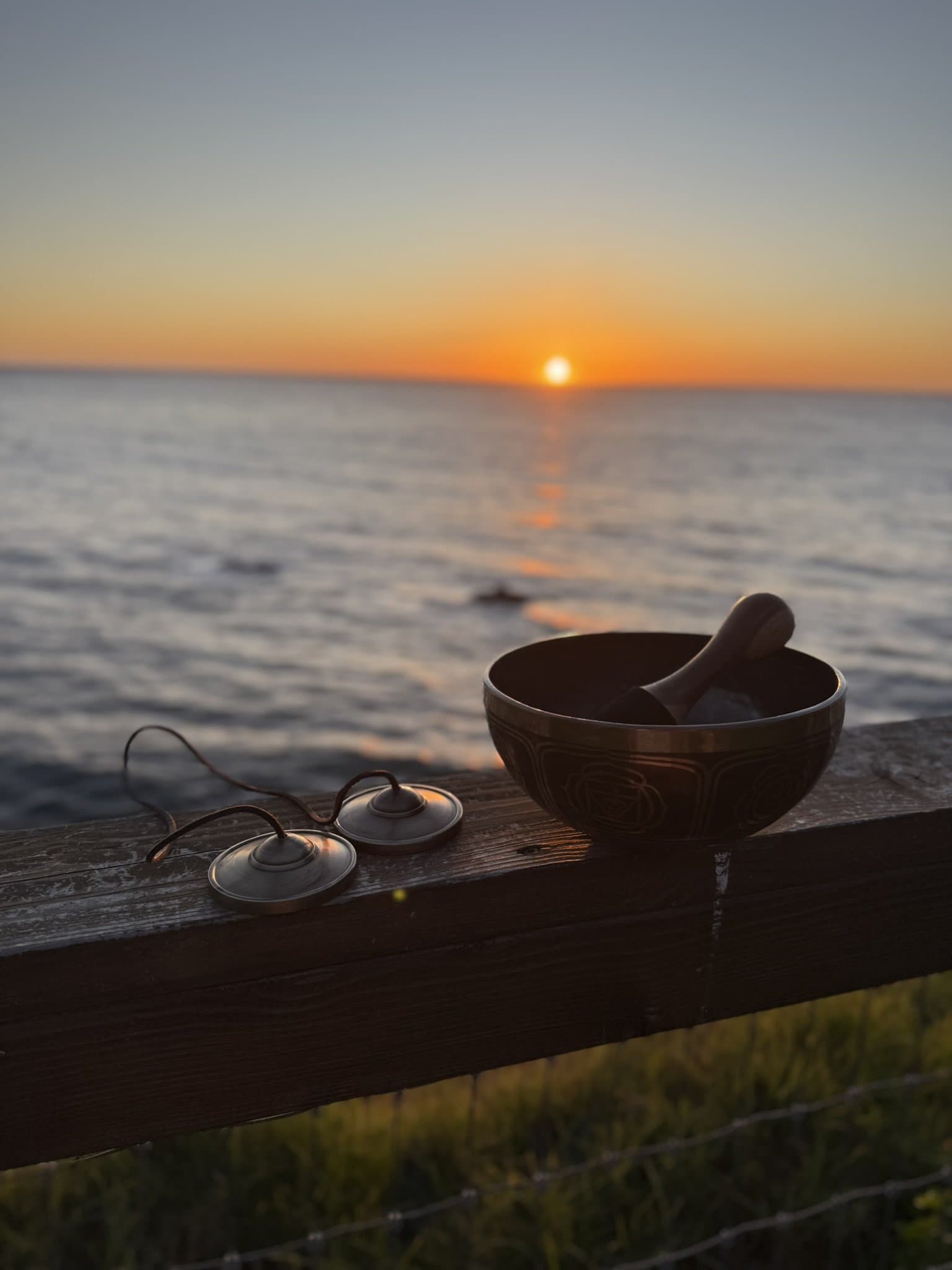 A singing bowl on a ledge at sunset