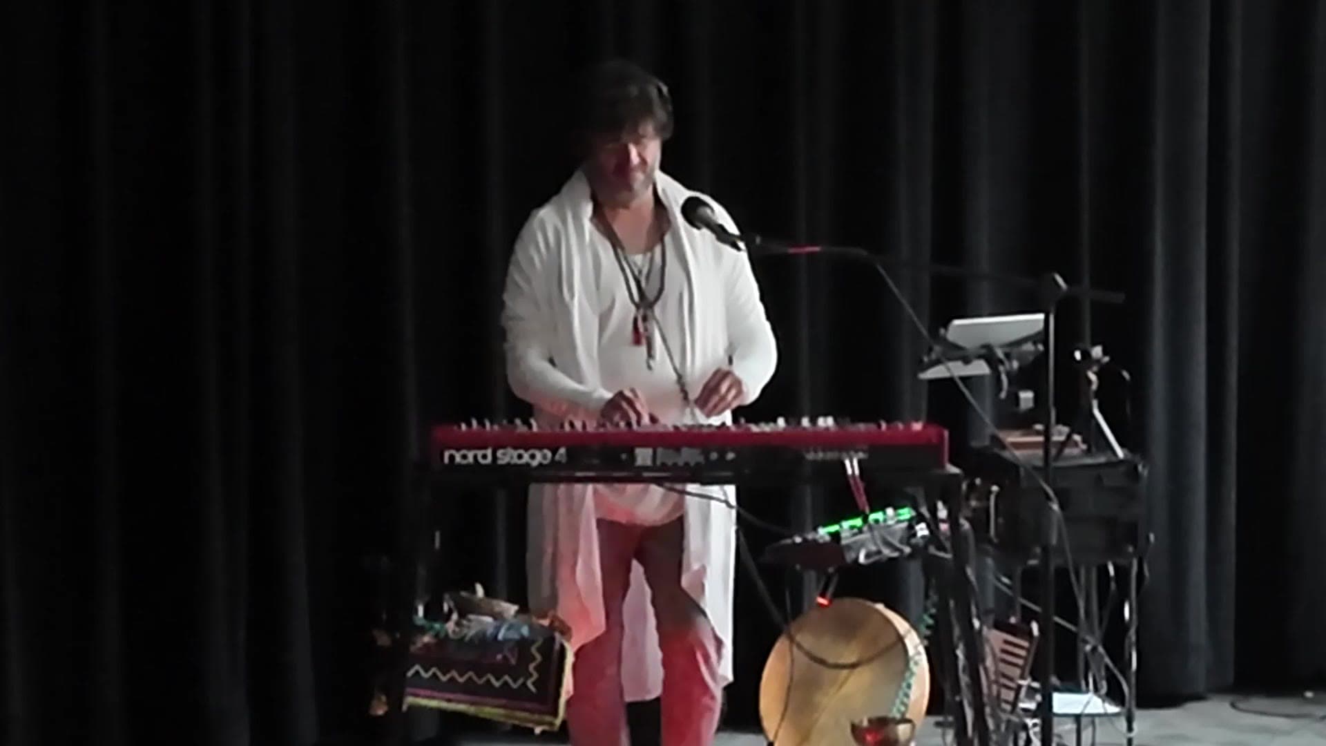 Dustin Wells at the keyboard with frame drum and singing bowls, Wilkinson Public Library