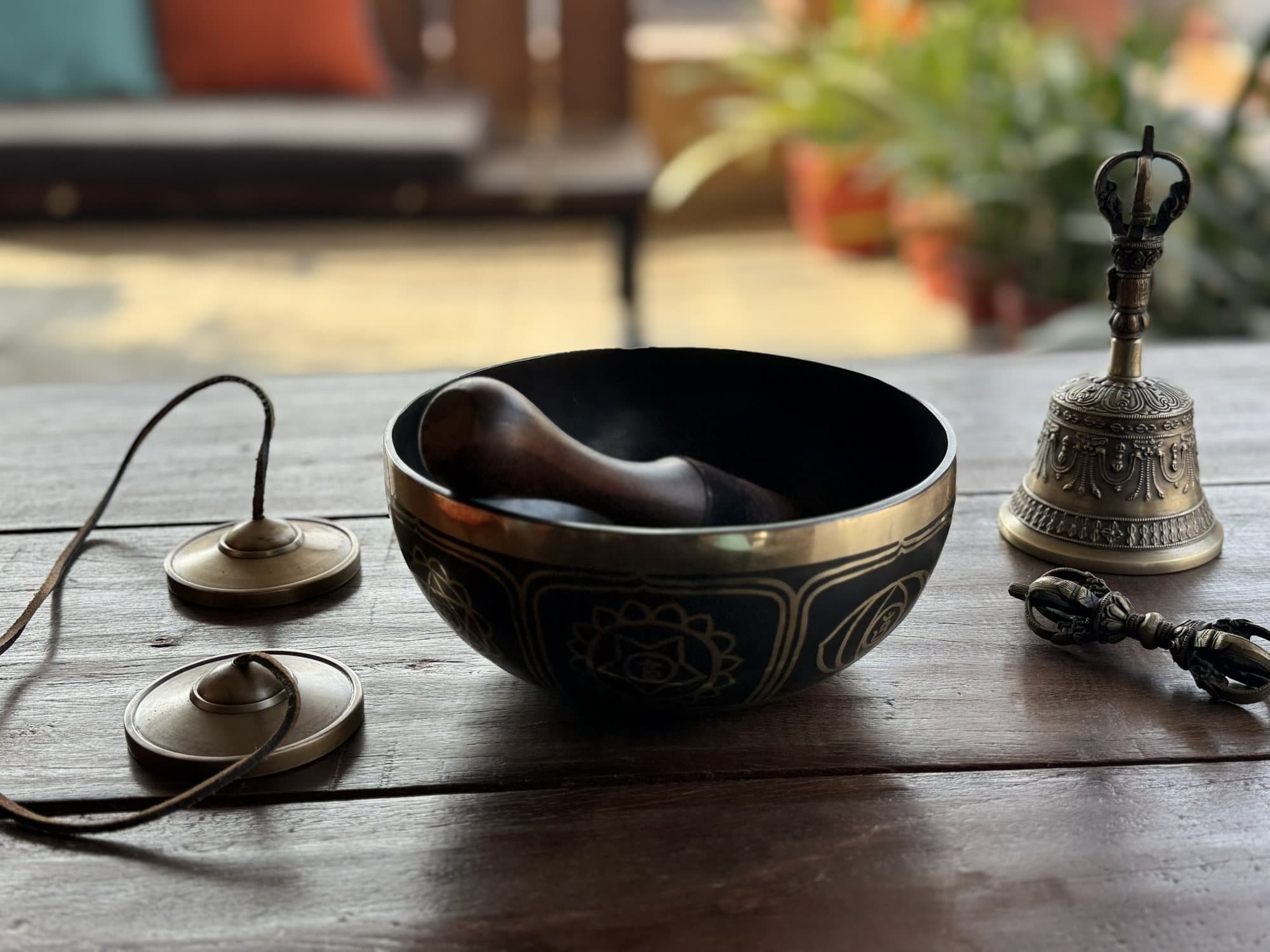 A singing bowl and hand bell resting together