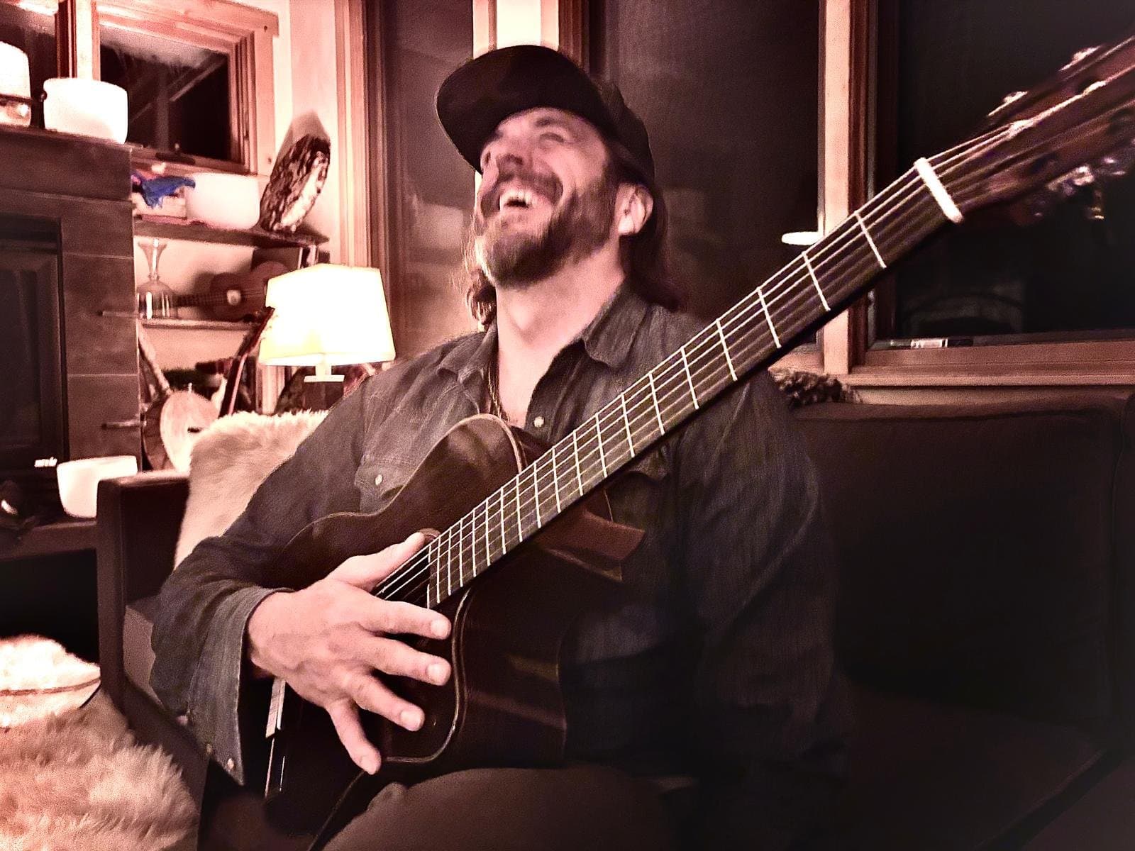 Dustin laughing with his guitar