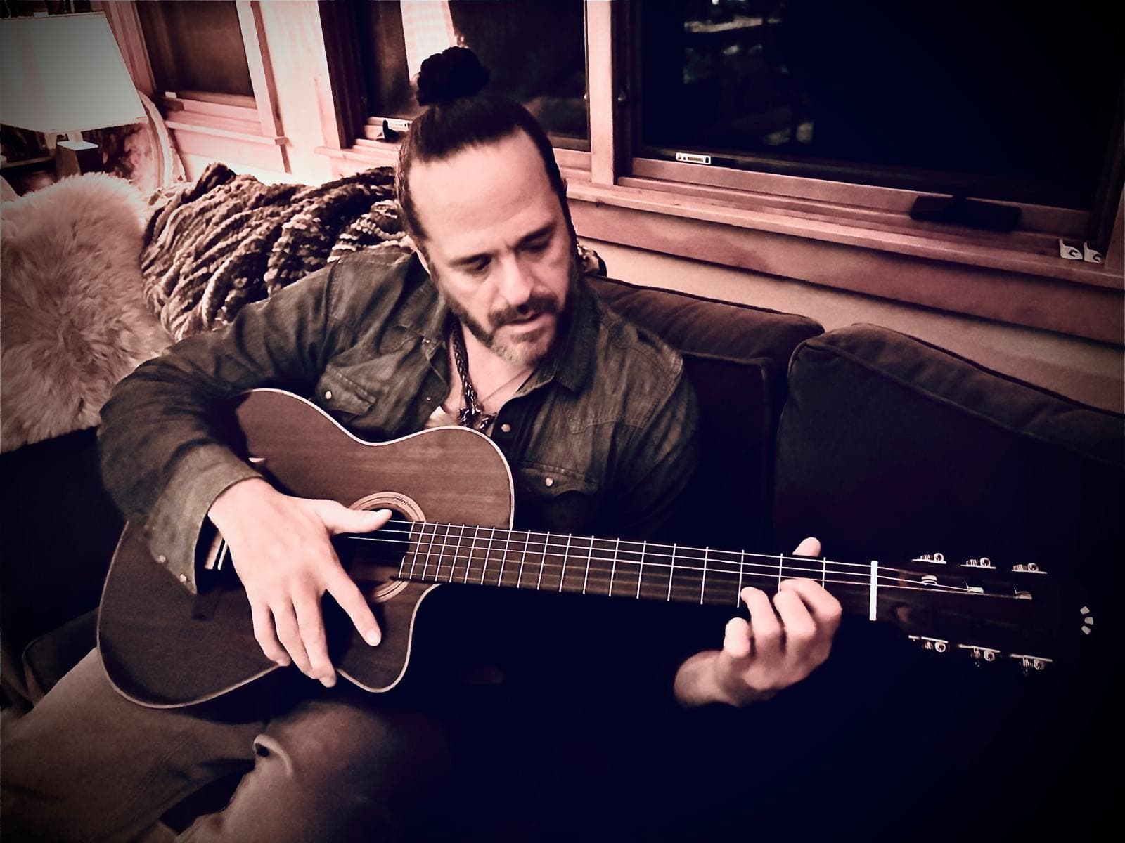 Listening, guitar in hand